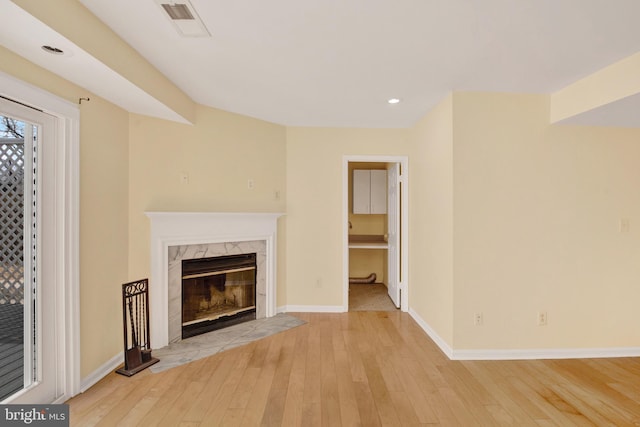 6135 Rainbow Dr, Elkridge, MD 21075 - unfurnished living room featuring visible vents, baseboards, recessed lighting, light wood-style flooring, and a premium fireplace