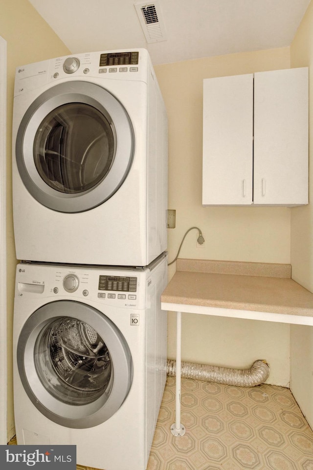 6135 Rainbow Dr, Elkridge, MD 21075 - washroom with cabinet space, visible vents, and stacked washer / drying machine