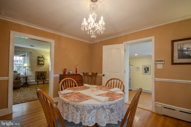 dining area with crown molding, baseboard heating, light wood-style floors, a chandelier, and baseboards