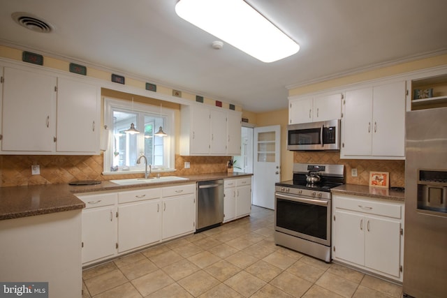 kitchen featuring white cabinets, a sink, stainless steel appliances, tasteful backsplash, and visible vents