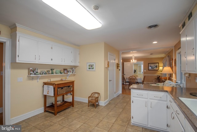 kitchen featuring white cabinetry, baseboards, visible vents, and light tile patterned floors