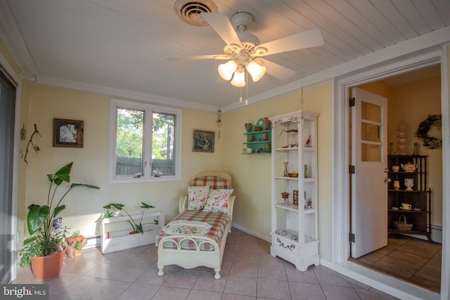 living area featuring tile patterned flooring, a ceiling fan, a baseboard heating unit, and visible vents