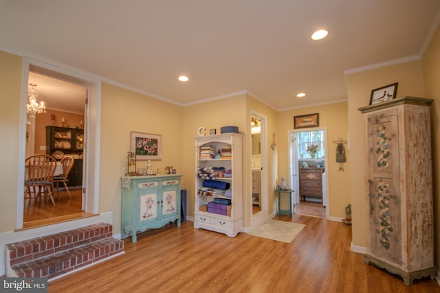 entryway featuring an inviting chandelier, crown molding, light wood-style floors, baseboards, and recessed lighting