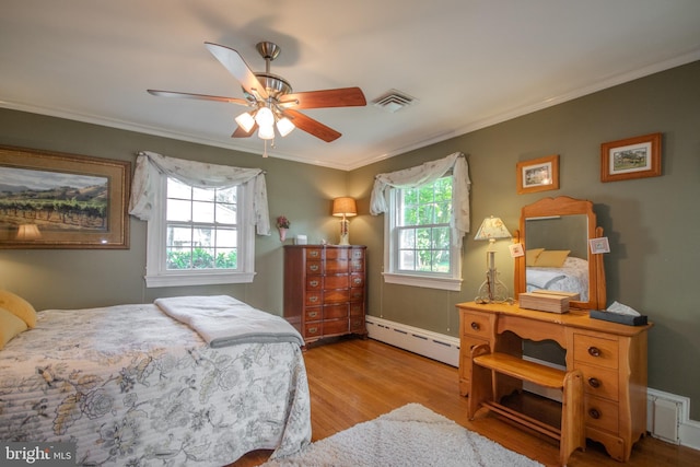 bedroom with crown molding, baseboard heating, wood finished floors, and visible vents