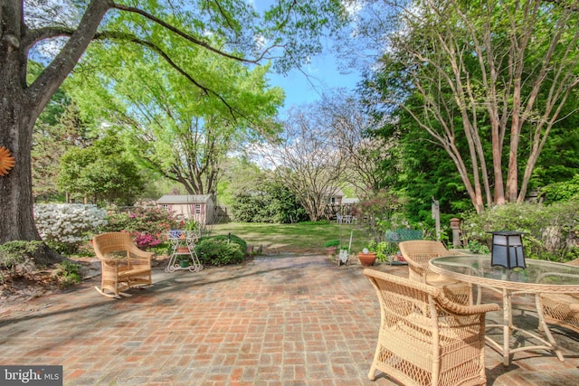 view of patio / terrace featuring a storage shed, an outdoor structure, and outdoor dining area
