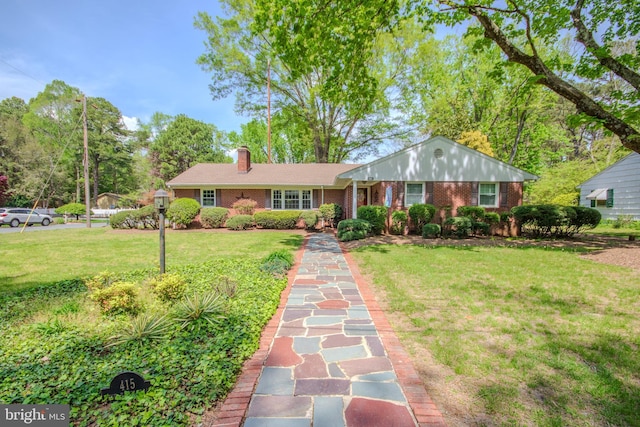 ranch-style home with brick siding, a chimney, and a front lawn