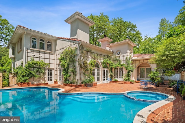 1405 N Pegram St, Alexandria, VA 22304 - back of property featuring stucco siding, french doors, a chimney, a tiled roof, and a pool with connected hot tub