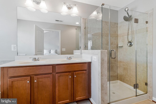 bathroom featuring visible vents, a sink, double vanity, and a shower stall