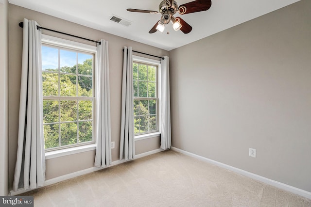 unfurnished room with visible vents, baseboards, ceiling fan, and light colored carpet