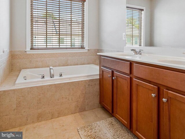 bathroom featuring double vanity, a sink, tile patterned flooring, and a garden tub