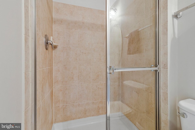 full bath with toilet and a shower stall