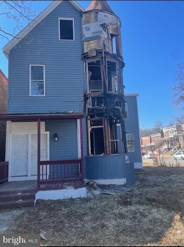 rear view of property featuring a porch