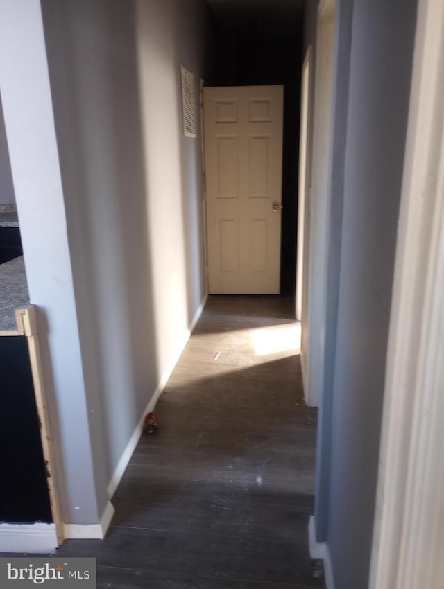 hall with baseboards and wood finished floors