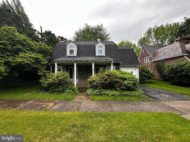 104 Amherst Ave, Reading, PA 19609 - dutch colonial featuring a chimney, covered porch, a front lawn, an attached garage, and asphalt driveway