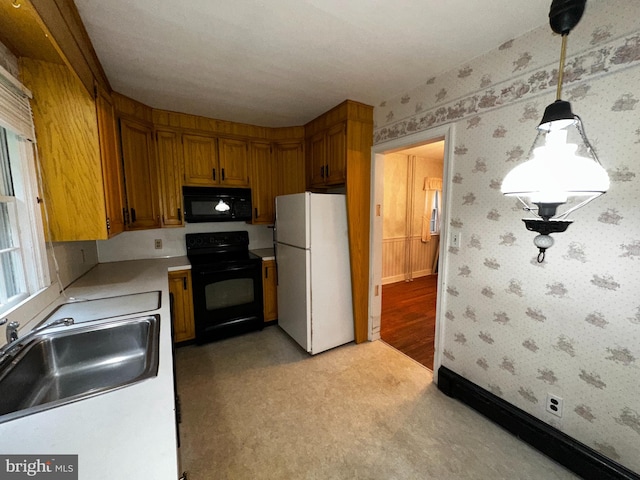 104 Amherst Ave, Reading, PA 19609 - kitchen featuring black appliances, a sink, light countertops, wallpapered walls, and brown cabinets