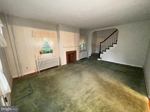 104 Amherst Ave, Reading, PA 19609 - unfurnished living room featuring radiator heating unit, stairs, and carpet floors
