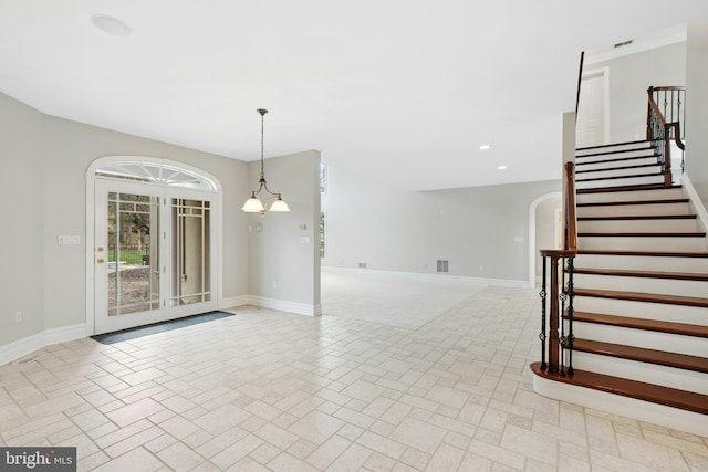 interior space featuring visible vents, baseboards, arched walkways, recessed lighting, and stairs
