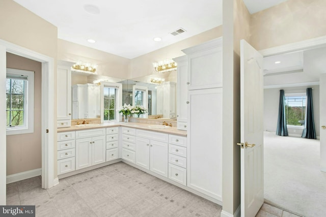 full bath with a sink, visible vents, double vanity, and a notable chandelier