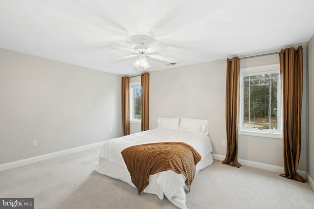 bedroom with baseboards, a ceiling fan, and light carpet