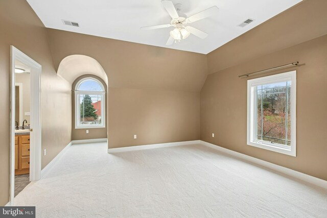 additional living space with ceiling fan, vaulted ceiling, visible vents, and a wealth of natural light