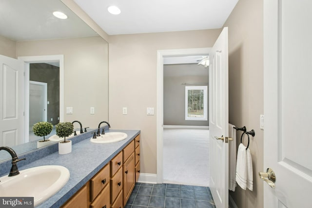 bathroom with double vanity, a sink, tile patterned flooring, and recessed lighting