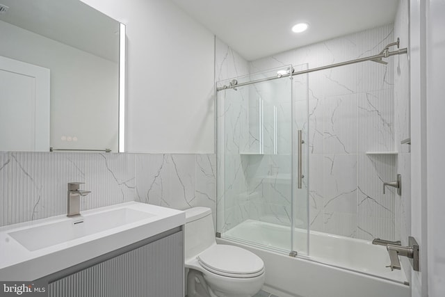 1143 Tasker St, Philadelphia, PA 19148 - bathroom featuring vanity, tile walls, bath / shower combo with glass door, toilet, and visible vents