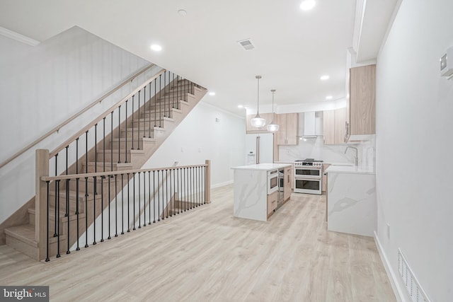 1143 Tasker St, Philadelphia, PA 19148 - kitchen with wall chimney range hood, light wood-type flooring, double oven range, visible vents, and a kitchen island