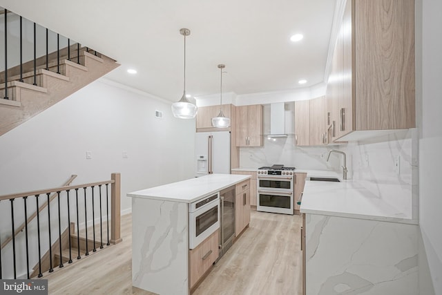 1143 Tasker St, Philadelphia, PA 19148 - kitchen featuring high end appliances, wall chimney range hood, light brown cabinets, and a sink