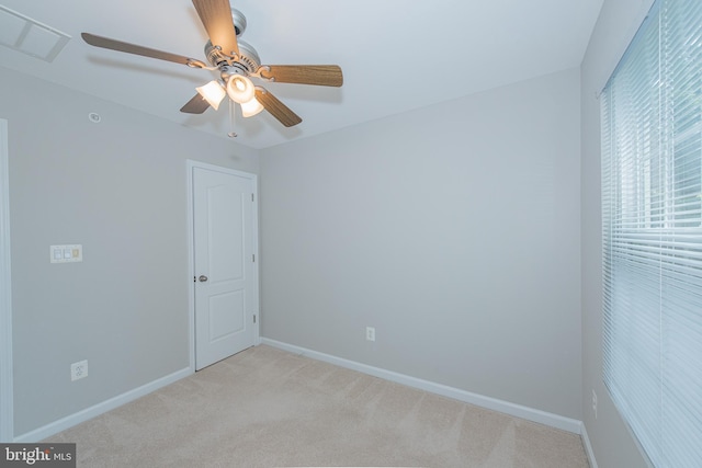 empty room featuring baseboards, visible vents, a ceiling fan, and light colored carpet
