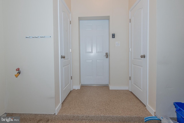 hallway featuring baseboards and light colored carpet