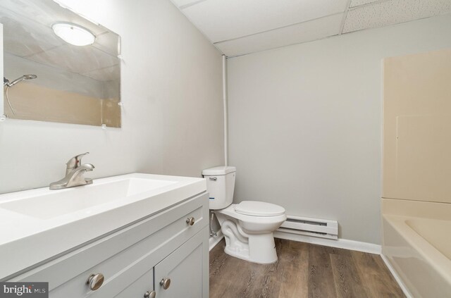 606 N St, Lykens, PA 17048 - bathroom with wood finished floors, toilet, vanity, a paneled ceiling, and baseboard heating