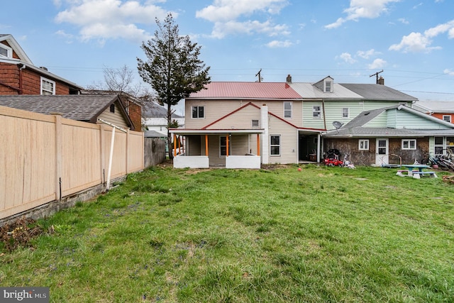 606 N St, Lykens, PA 17048 - rear view of property featuring fence, a yard, a sunroom, and metal roof