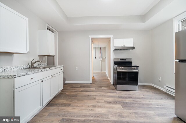 606 N St, Lykens, PA 17048 - kitchen with a baseboard radiator, white cabinetry, appliances with stainless steel finishes, and under cabinet range hood