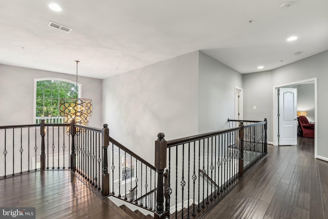 hallway featuring visible vents, recessed lighting, wood finished floors, and an upstairs landing