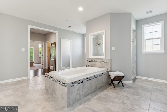 full bath featuring baseboards, a garden tub, recessed lighting, and visible vents