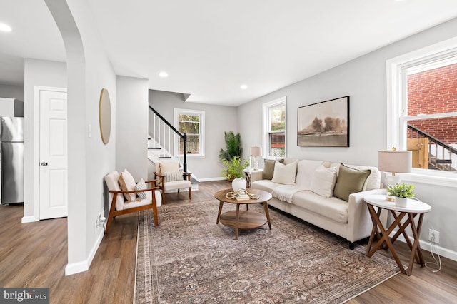 4319 Valley View Ave, Baltimore, MD 21206 - living room with baseboards, arched walkways, wood finished floors, and stairs