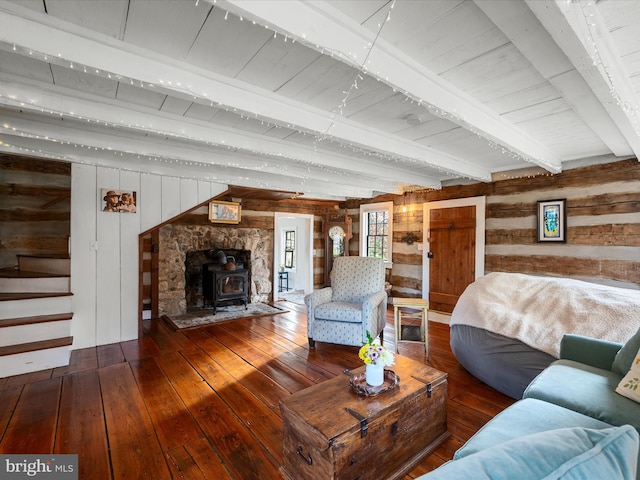 living room featuring wood ceiling, beamed ceiling, wood walls, hardwood / wood-style floors, and a wood stove