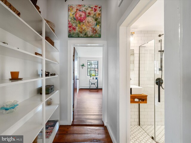 hall featuring baseboards and dark wood-style floors
