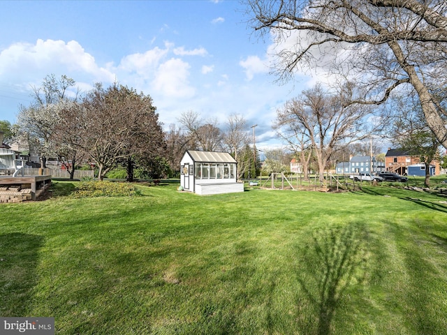 view of yard with an outbuilding, a vegetable garden, and a greenhouse