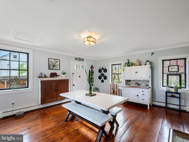 dining area with a baseboard heating unit, attic access, crown molding, and dark wood-type flooring