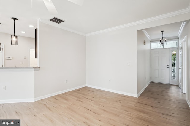 entryway featuring crown molding, wood finished floors, an inviting chandelier, baseboards, and visible vents