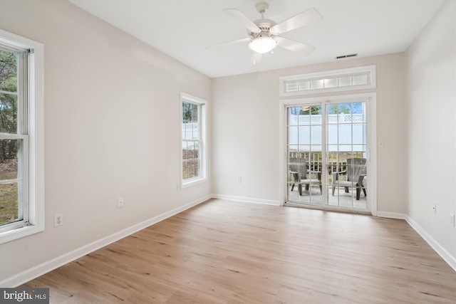 unfurnished room with baseboards, a healthy amount of sunlight, and light wood-type flooring