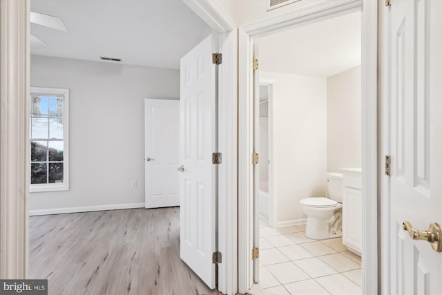 bathroom with toilet, wood finished floors, visible vents, and baseboards