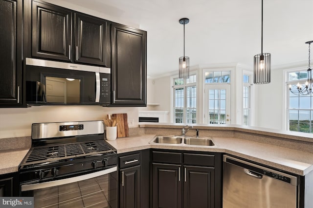 kitchen with a sink, an inviting chandelier, stainless steel appliances, decorative light fixtures, and ornamental molding