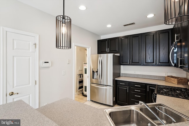kitchen featuring dark cabinets, visible vents, appliances with stainless steel finishes, and a sink