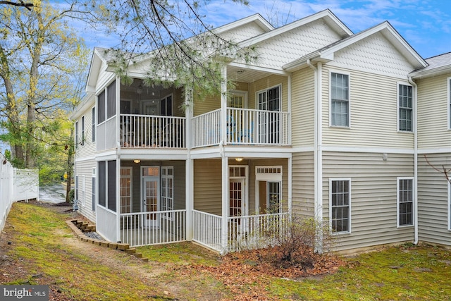 back of house with fence, a sunroom, and a balcony