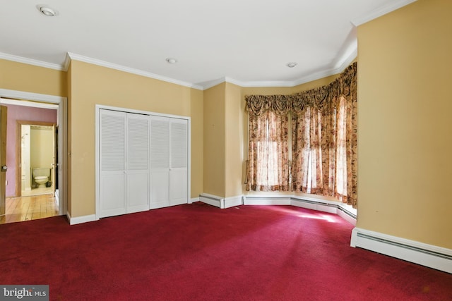 unfurnished bedroom featuring a baseboard heating unit, baseboards, a closet, crown molding, and carpet floors