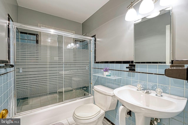 3820 Lorcom Ln, Arlington, VA 22207 - full bathroom with tile walls, toilet, bath / shower combo with glass door, and a sink