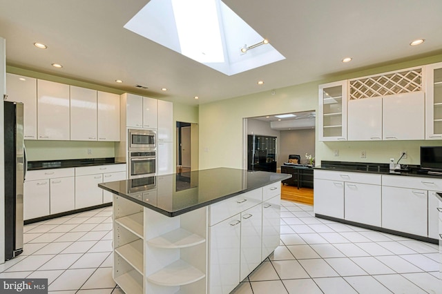 3820 Lorcom Ln, Arlington, VA 22207 - kitchen featuring recessed lighting, dark countertops, a skylight, appliances with stainless steel finishes, and white cabinetry