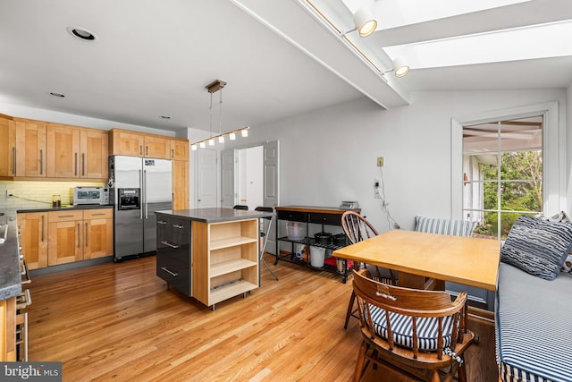 kitchen featuring light wood-style flooring, open shelves, high quality fridge, dark countertops, and backsplash